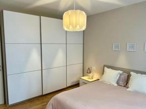 sypialnia z dużym białym łóżkiem i żyrandolem w obiekcie Residenza Bramante w mieście Olbia
