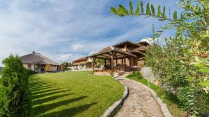 une maison avec une cour herbeuse devant elle dans l'établissement Woodland Resort, à Kragujevac