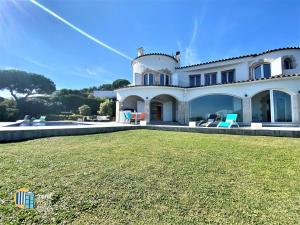 a large house with a lawn in front of it at Villa Saramel con vistas panorámicas al mar in Sant Antoni de Calonge