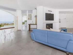 a blue couch in a living room with a fireplace at Villa Saramel con vistas panorámicas al mar in Sant Antoni de Calonge