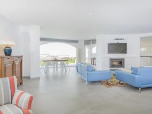 a living room with blue chairs and a fireplace at Villa Saramel con vistas panorámicas al mar in Sant Antoni de Calonge