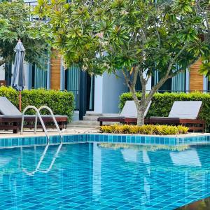 チャン島にあるEvergreen Koh Chang Resortのスイミングプール(椅子2脚、木付)