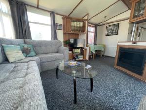 sala de estar con sofá y chimenea en 27 Tower View Pevensey Bay Holiday Park en Pevensey