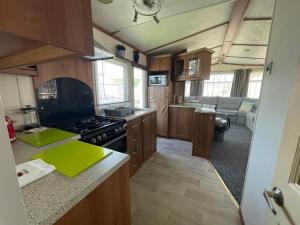 a kitchen with wooden cabinets and a stove top oven at 27 Tower View Pevensey Bay Holiday Park in Pevensey