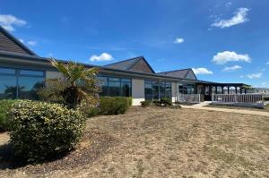 a building with a palm tree in front of it at 27 Tower View Pevensey Bay Holiday Park in Pevensey