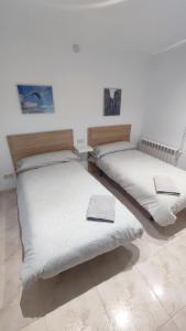two beds in a room with white walls at La Quadra de Quelo 3 in Àger