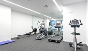 een fitnessruimte met loopbanden en crosstrainers bij Sky Stars Park Apartment in Auckland
