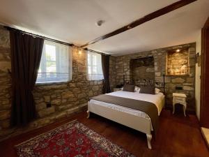 a bedroom with a bed and a stone wall at Urla Taş Konak Otel in İzmir