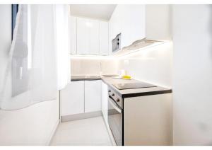 a white kitchen with a sink and a stove at S`akvarel 7 - new & modern studio in Split