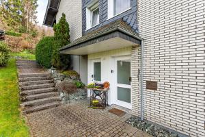 una casa con una puerta blanca y escaleras al lado en Haus Frigger, en Olsberg