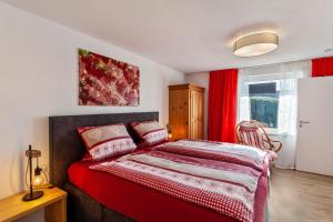 1 dormitorio con 1 cama con cortinas rojas en Haus Frigger, en Olsberg