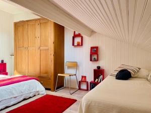 a bedroom with a bed and a cabinet and a chair at Villa Les coquelicots La Baule in La Baule