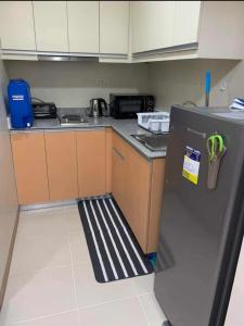 uma pequena cozinha com um frigorífico e um lavatório em SW 15L, The Palladium, Megaworld Blvd. Iloilo City em Iloilo