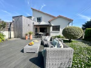 a patio with two wicker chairs and a table at Villa Les coquelicots La Baule in La Baule