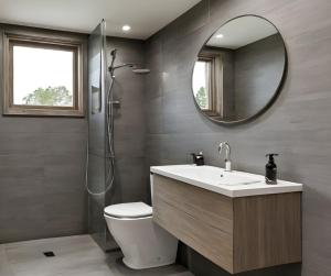 a bathroom with a toilet and a sink and a mirror at Alagalla Terrace in Kadugannawa