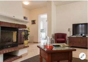 a living room with a fireplace and a tv at Il Conero Bilocale con posto auto privato in Osimo