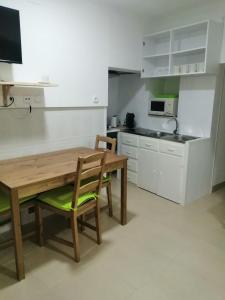 a kitchen with a wooden table and chairs at Casa da Romeira in Elvas