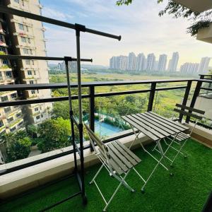 a balcony with a table and a chair on the grass at Ataraxia park condo forest city in Gelang Patah