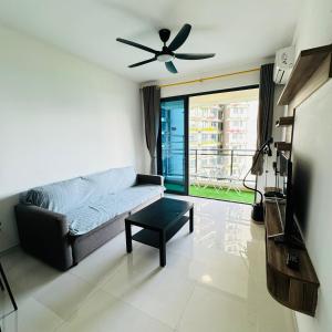 a living room with a couch and a ceiling fan at Ataraxia park condo forest city in Gelang Patah