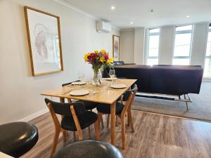 a dining room with a table and chairs and a couch at Spacious & Luxurious Newtown Central in Wellington