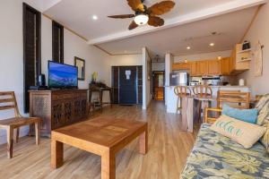 een woonkamer en keuken met een bank en een tafel bij Kuleana Resort 207 in Kahana