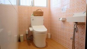 a bathroom with a toilet with a basket on top of it at ONE Miyakojima in Miyako Island
