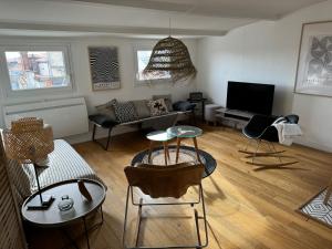 ein Wohnzimmer mit einem Sofa und einem TV in der Unterkunft ღ La Cabane Rochelaise • Vue sur le vieux-port in La Rochelle