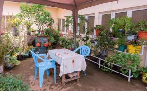 une table et des chaises dans un jardin avec des plantes dans l'établissement FARAJA HOMESTAY- Seamless Comfort in the Heart of the City - Free WiFi, Warm Hospitality, and Local Delights Await, à Moshi