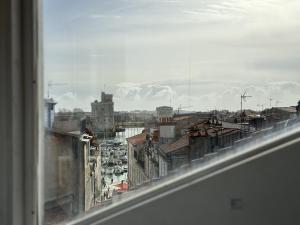 una vista de una ciudad desde una ventana en ღ La Cabane Rochelaise • Vue sur le vieux-port, en La Rochelle