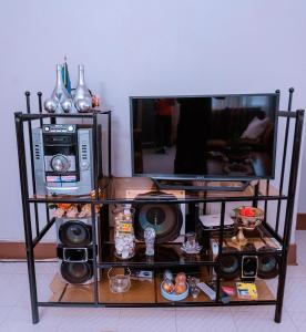 a tv stand with speakers and a television at FARAJA HOMESTAY- Seamless Comfort in the Heart of the City - Free WiFi, Warm Hospitality, and Local Delights Await in Moshi