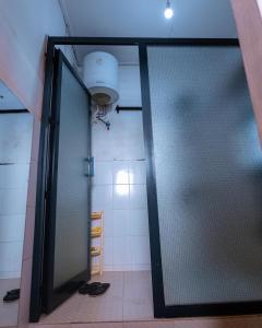 baño con ducha y puerta de cristal en FARAJA HOMESTAY- Seamless Comfort in the Heart of the City - Free WiFi, Warm Hospitality, and Local Delights Await en Moshi