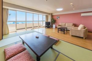 a living room with a couch and a table at Maholova Minds Miura in Miura