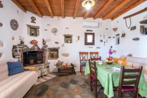 a living room with a table and a fireplace at Savvas's Traditional House Paros in Episkopianá