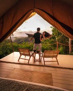 un homme debout dans une tente avec deux chaises dans l'établissement Autentik Penida "Glamping" - Adults only, à Nusa Penida