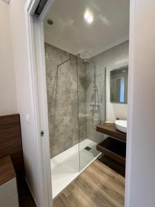 een badkamer met een glazen douche en een wastafel bij B&B Palazzo Croghan in Torre Maggiore