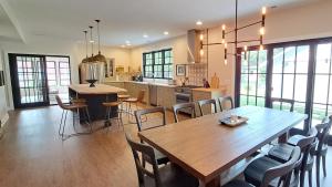 Una gran cocina con una mesa y sillas de madera. en Bold Stump Cottage, en Lakeside