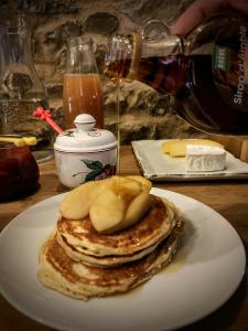 una pila de panqueques en un plato en una mesa en Chambres et tables d'hôtes Cornec en Ploubazlanec