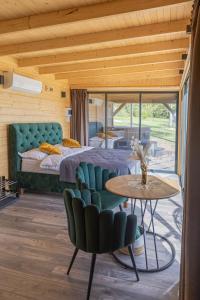 a bedroom with a bed and a table and chairs at Doles Perle in Ķekava