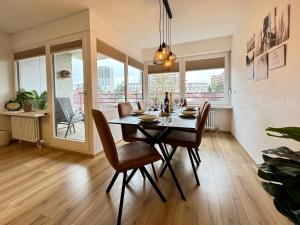 a dining room with a table and chairs and windows at 3 Zimmer Apartment, 95 qm, max 5 Personen, Balkon, Garage, Internet 100 MBit in Leonberg