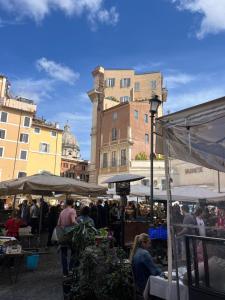a group of people at an outdoor market with buildings at Sweet House Campo de’ Fiori in Rome
