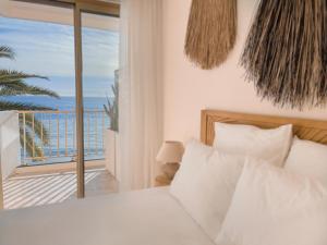 a bedroom with a bed and a view of the ocean at Soleil Riviera Apartament Côte d’Azur in Roquebrune-Cap-Martin