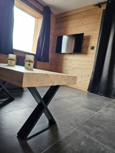 a wooden table in a room with a tv at Appartement bas de chalet in Font-Romeu-Odeillo-Via