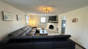 ein Wohnzimmer mit einem schwarzen Sofa und einem Kamin in der Unterkunft Drift Away Den in Stevensville