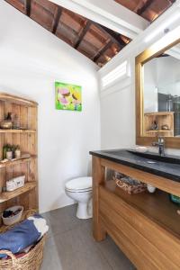 ein Bad mit einem Waschbecken und einem WC in der Unterkunft Maison d'Ô Pointe Thalémont, avec petite crique privative in Le François