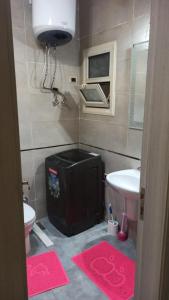 La salle de bains est pourvue d'un lavabo, de toilettes et de tapis roses. dans l'établissement The Groove Ain Sokhna, à Ain Sokhna