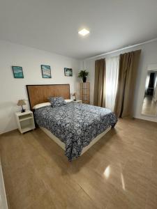 Schlafzimmer mit einem Bett und Holzboden in der Unterkunft El Refugio de Santa Maria Grupo Ac Gestion in Cádiz