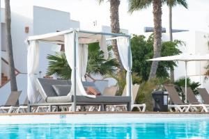 una piscina con sillas y un cenador junto a una piscina en Labranda Bahía de Lobos en Corralejo