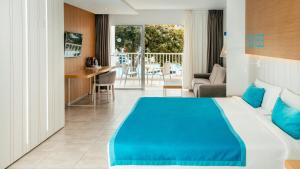 een hotelkamer met een blauw bed en een balkon bij Labranda Bahía de Lobos in Corralejo