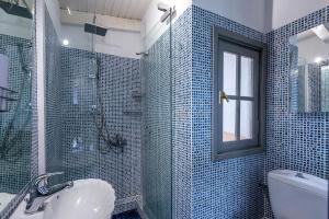a bathroom with a sink and a shower with blue tiles at Selianitika Bay Γ2 Loft in Selianitika