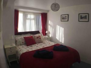 una camera da letto con un letto con lenzuola rosse e una finestra di The Post House (Centre of riverside village) a Stoke Gabriel